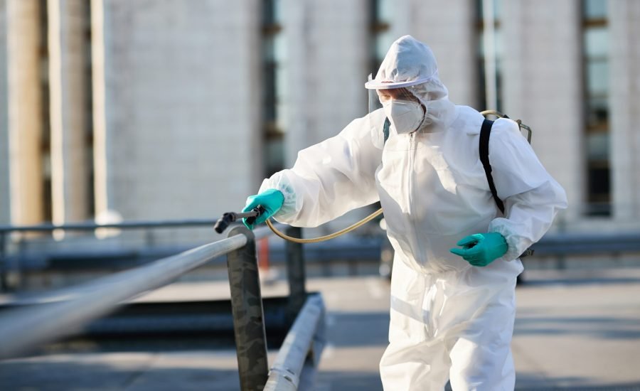 Disinfectant worker cleaning city streets during COVID-19 pandemic.
